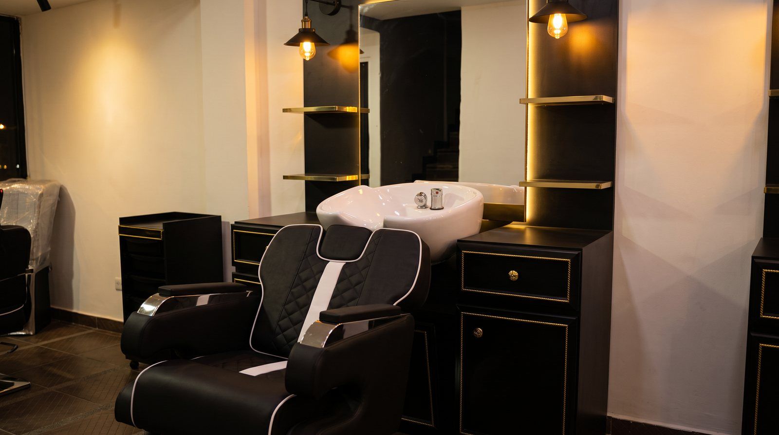 Combo Visajoso instalado en barbería con luz cálida, silla en cordobán negro y poceta blanca en diagonal