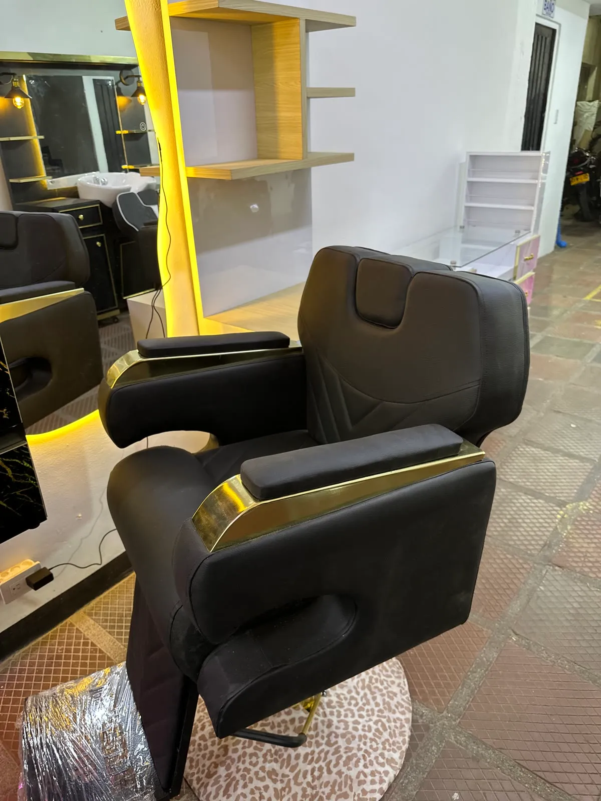 Silla Milán reclinable en cordobán negro con herrajes dorados, foto real en el showroom