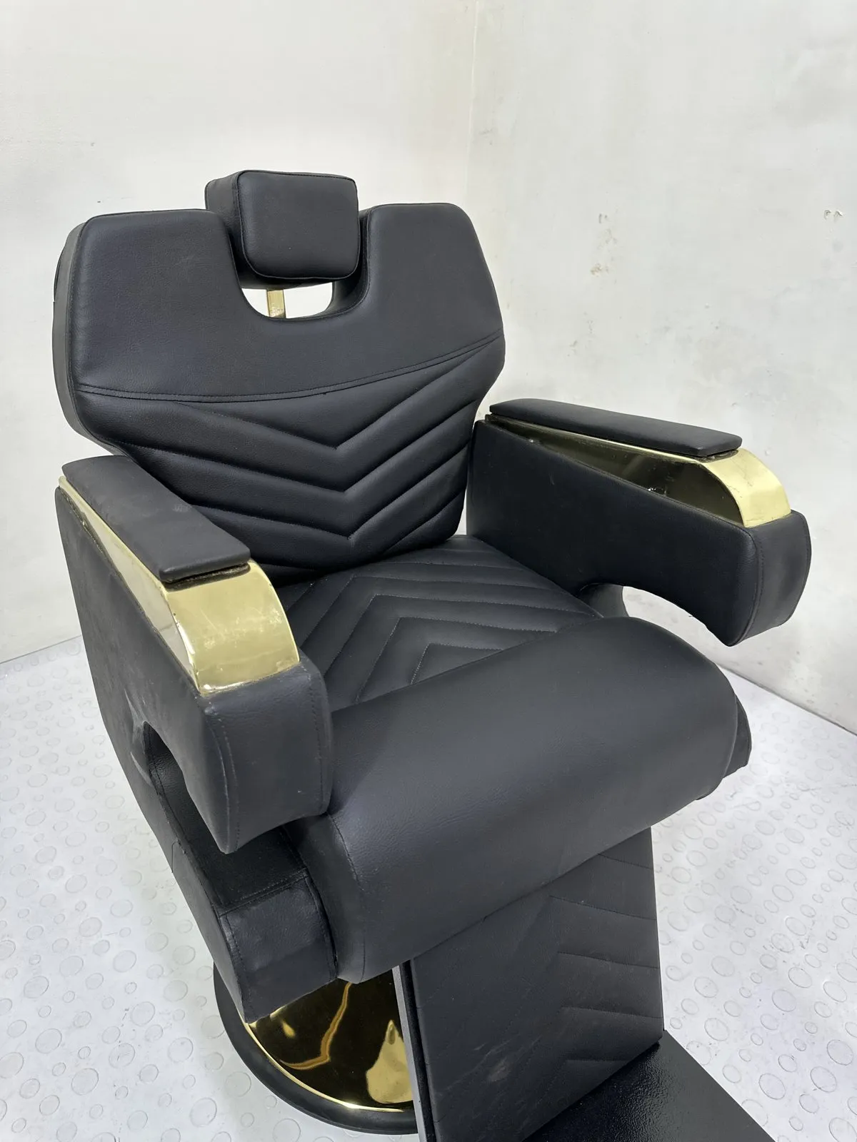 Silla de barbería Milán en cordobán negro con capitoné en V y herrajes dorados, foto real